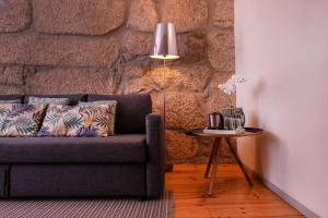 a living room with a couch and a table with a lamp at OportoHouse in Porto