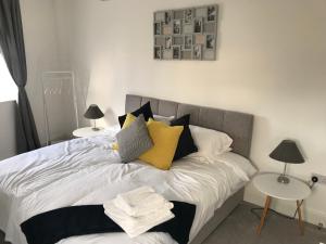 ein Schlafzimmer mit einem Bett mit gelben und schwarzen Kissen in der Unterkunft Bellevue Apartment in Bristol