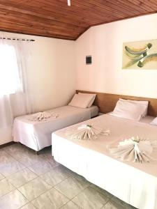 Dos camas una al lado de la otra en una habitación. en Hotel Fazenda Bandeirantes, en Ibiúna