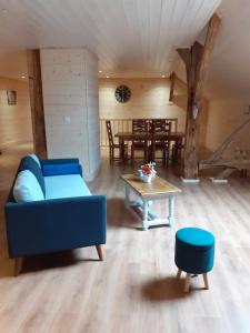 a living room with a blue couch and a table at LES TROIS CHARMES in Chaucenne +16 photos