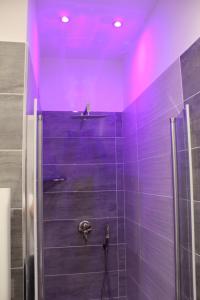 una doccia con illuminazione viola in bagno di Dante Relais a Napoli Altre 68 foto