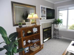 a living room with a fireplace and a mirror at Hammond Bay Oceanside Guesthouse in Nanaimo