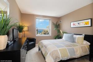 a bedroom with a bed and a desk and a window at The Penthouse at Grand Plaza in Chicago