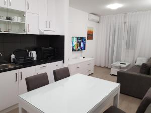 a kitchen and living room with a table and a couch at Apartment GEA 39 in Novi Sad