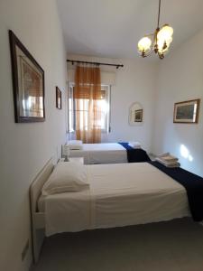 sypialnia z 2 łóżkami i żyrandolem w obiekcie Domus Mater w Cagliari