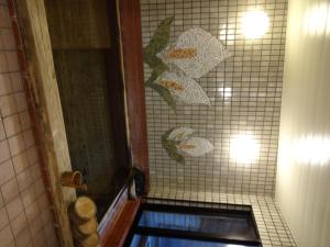 uma casa de banho com um chuveiro e uma parede de azulejos em Mizubasho no Yado Higashi em Katashina