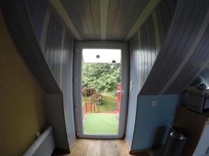 un couloir avec une porte menant à une aire de jeux dans l'établissement Halte nature à Briac Connemara, à Bourbriac