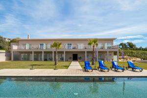 una villa con piscina e sedie blu di Pestana Gramacho Residences a Ferragudo