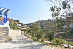an empty road with a hill in the background at Blue Horizon Ios in Ios Chora +5 photos