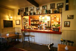 a bar in a pub with two tables and chairs at The Tomich Hotel in Inverness