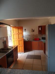 a kitchen with wooden cabinets and a refrigerator at Salt Life in Port Shepstone