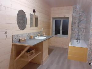 a wooden bathroom with a sink and a mirror at LES TROIS CHARMES in Chaucenne