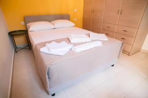 1 dormitorio con 1 cama con 2 toallas en Ioannina City Relax Apartment, en Ioannina