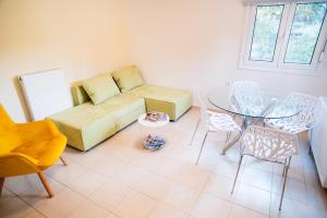 a living room with a couch and a table and chairs at Ioannina City Relax Apartment in Ioannina