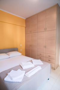 Ioannina City Relax Apartment في يوانينا: غرفة نوم بسريرين ودواليب خشبية