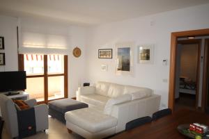 sala de estar con sofá blanco y TV en Deluxe Padova Apartment, en Rubano