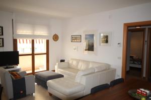 een woonkamer met een witte bank en een tv bij Deluxe Padova Apartment in Rubano