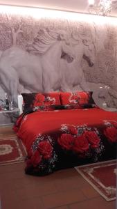 een slaapkamer met een bed met rode lakens en rode rozen bij La Luna in Impruneta