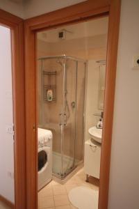 y baño con ducha y lavadora. en Deluxe Padova Apartment, en Rubano