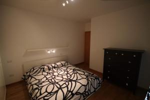 1 dormitorio con 1 cama en blanco y negro y vestidor en Deluxe Padova Apartment, en Rubano