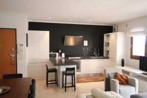 een keuken met witte kasten en een zwarte muur bij Deluxe Padova Apartment in Rubano