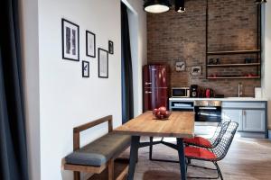 a kitchen with a wooden table and chairs and a refrigerator at Kolonaki 8 - Design Suites & Lofts in Athens