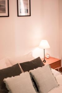 1 cama con 2 almohadas y mesa con lámpara en Au Coeur De La Ville, en Honfleur