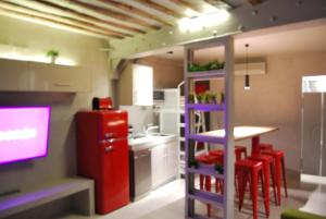 eine Küche mit einem roten Kühlschrank und einem Tisch mit roten Stühlen in der Unterkunft Apartamento NAO MALASAÑA - GRAN VIA in Madrid
