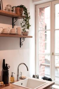 a kitchen with a sink and a window at Au Coeur De La Ville in Honfleur