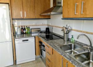 een keuken met een wastafel en een vaatwasser bij Bright spacious 2 BDR Apt, near Arenal beach Javea , + FREE parking in Jávea