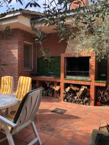 a patio with a table and chairs and a fireplace at El Freginal in Tartareu