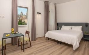 a bedroom with a bed and a table and a window at Hotel Canton dell'Orto in Padova