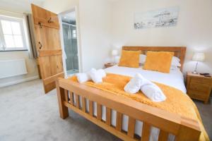 a bedroom with a large bed with towels on it at Sunnyside Barn in Truro