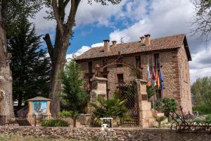 una casa de ladrillo con una valla delante de ella en Alojamiento Rural Molino Del Batan, en Molina de Aragón