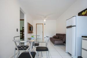 Il dispose d'une cuisine et d'un salon avec une table et un réfrigérateur. dans l'établissement Sun Way Apartamentos com piscinas e churrasqueiras, à Ubatuba