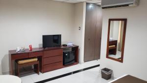 a room with a tv on a wooden dresser at Hotel Ramada in Guayaquil