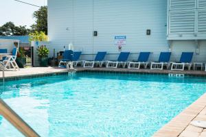 a swimming pool with blue chairs in a building at The Flagler Inn - Saint Augustine in St. Augustine
