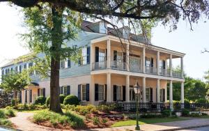 a large white house with a balcony on a street at Fort Conde Inn - Mobile in Mobile