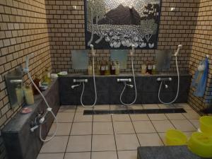 a bathroom with two shower heads and a sink at Hanasaku Onsen Yoshiyaso in Katashina +99 photos