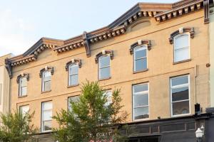 a brown building with white windows on the side of it at Sonder The Broughton in Savannah