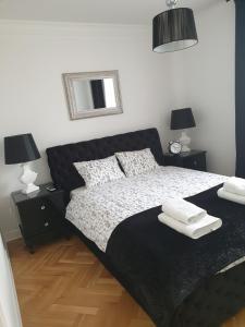 - une chambre avec un lit, 2 tables de nuit et 2 lampes dans l'établissement Apartament Twarda, à Varsovie