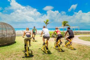 a group of people riding on an exercise bike at the beach at Sandos Cancun All Inclusive in Cancún