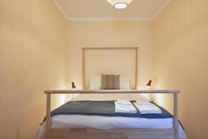een kleine slaapkamer met een bed met angthhedon bij Spacious and Renovated Apartment With Amazing Patio, By TimeCooler in Lissabon