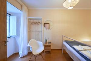een slaapkamer met een bed, een stoel en een spiegel bij Spacious and Renovated Apartment With Amazing Patio, By TimeCooler in Lissabon