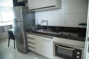 a kitchen with a stainless steel refrigerator and a sink at Beach Class, Ilha do Leite, Flat completo 1406 in Recife +8 photos