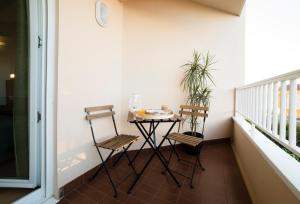 - Balcón con mesa pequeña y 2 sillas en Hotel Crisol de las Rías, en Miño