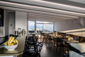 ein Restaurant mit Tischen und Stühlen und einem Balkon in der Unterkunft Upper - Boutique Hotel in Milazzo