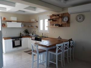 cocina con mesa y reloj en la pared en Michaela, en Gázion