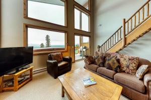 a living room with a couch and a tv at Arolla Chalet D in Big White