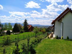a house in a green field with a fence at Domek z ogrodem na Hyrbie in Zarzecze